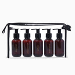 Set of 5 amber bottles with black pumps in a black travel case on a white background