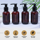 Set of four brown bottles labeled Shampoo, Conditioner, Lotion, and Body Wash on a white background with green leaves