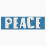 Blue sign with 'PEACE' and a smiley face on a white background