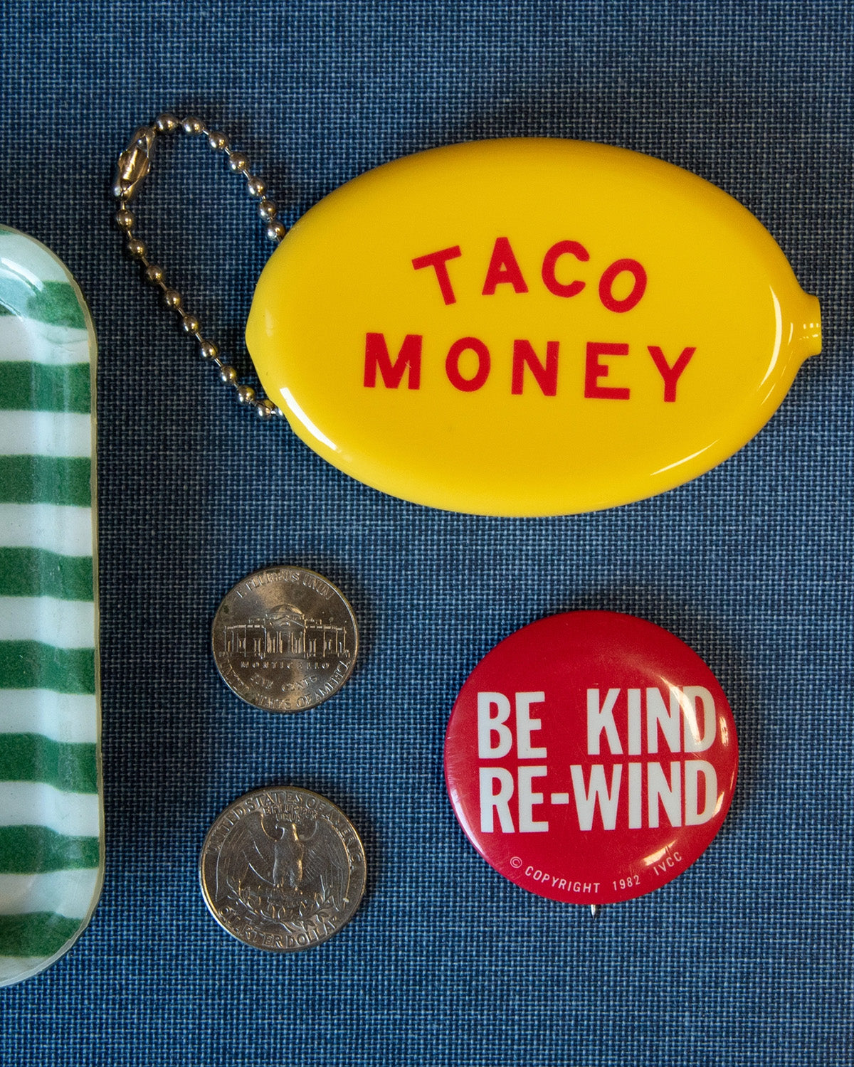 Yellow container labeled 'Taco Money' with a red button labeled 'Be Kind Re-Wind' on a blue textured background