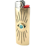 Brass lighter with eye design on a white background