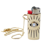 Gold lighter case with chain and eye design on a white background