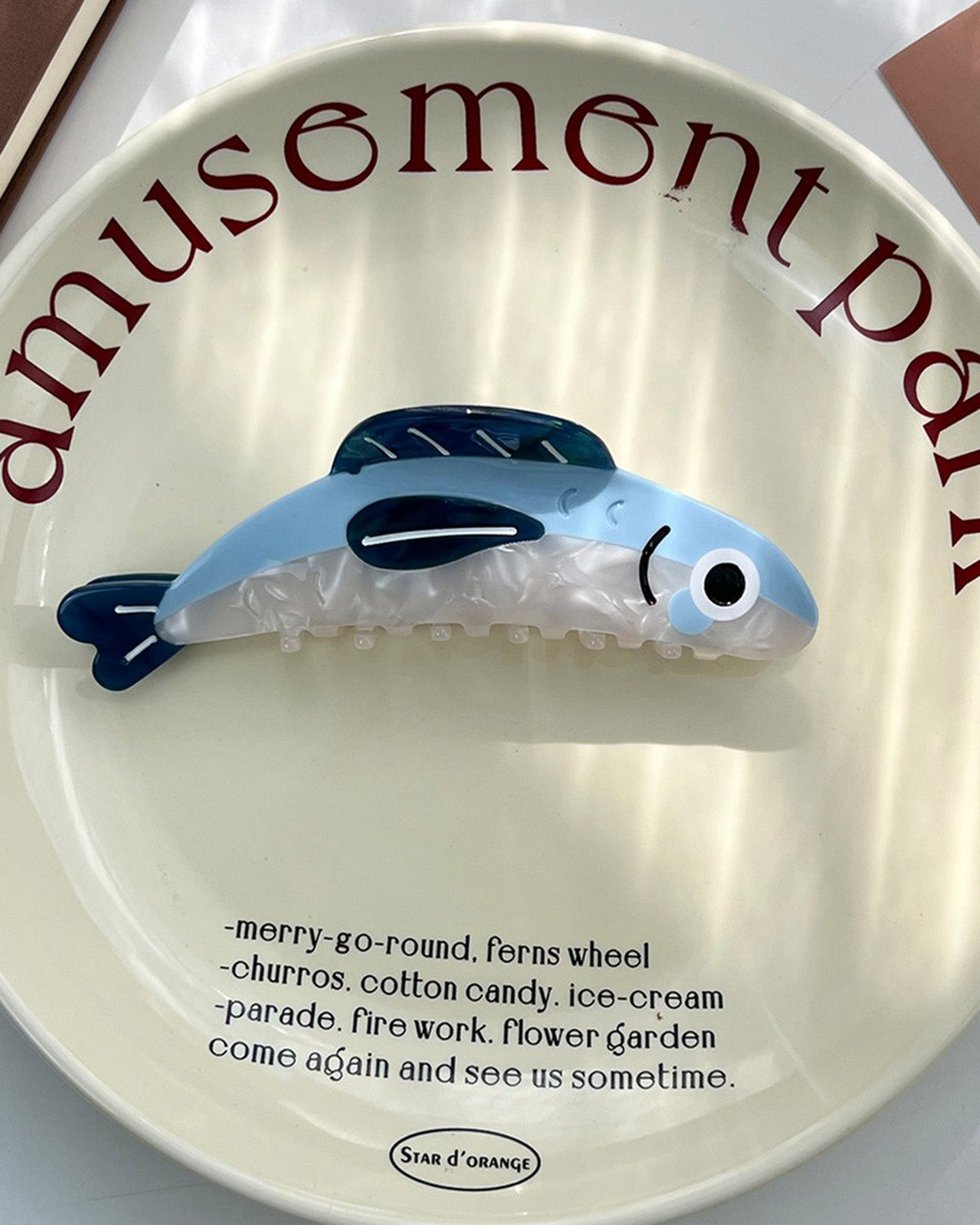 Toy whale on a plate with 'amusement park' text and a list of attractions