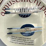 Two white combs with blue handles on a white plate with red text