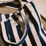 Close-up of a navy and white striped garment with a brand logo