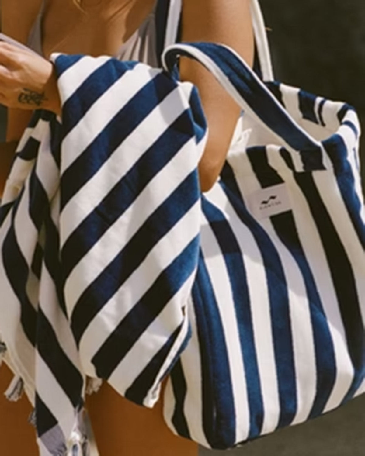 Two blue and white striped bags held by a person