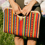 Model holding palm fiber woven red fiesta bag at angle