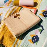 Palm fiber woven tan bag on blanket