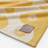 Yellow and beige fabric with floral patterns and a 'Slowtide' logo