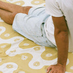 Person lying on a bed with a floral patterned bedspread