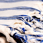 Close-up of a white and blue striped fabric with tassels