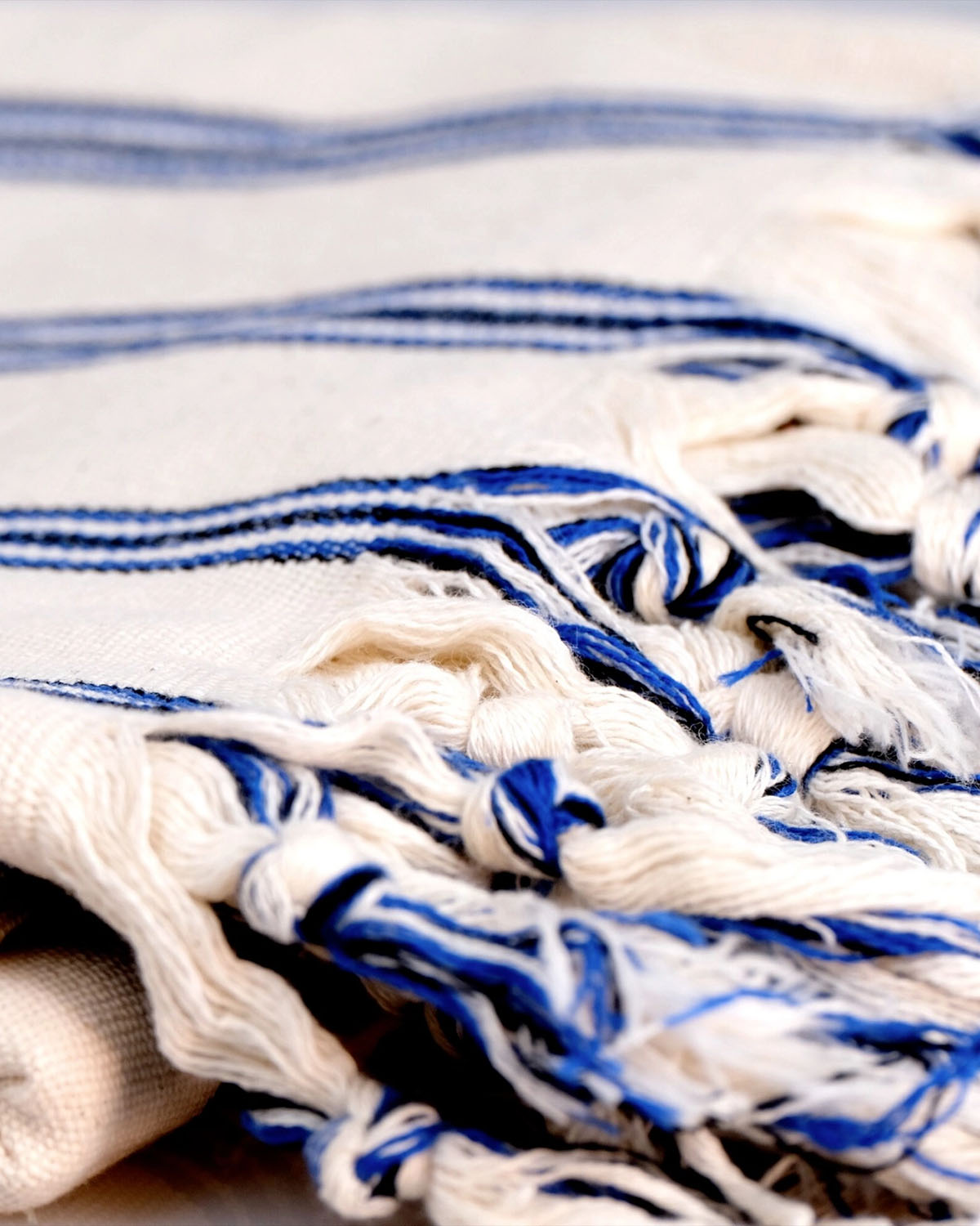 Close-up of a white and blue striped fabric with tassels