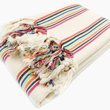 Striped blanket with colorful tassels on a white background