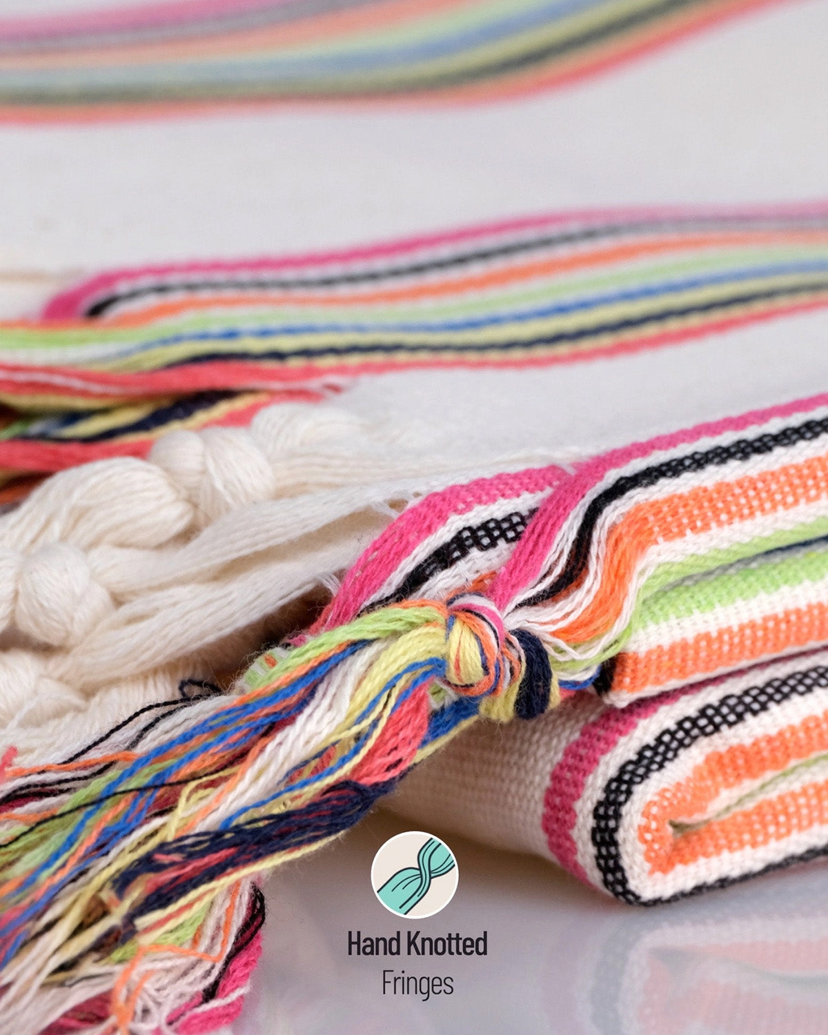 Colorful hand-knotted fringes on a textured fabric background