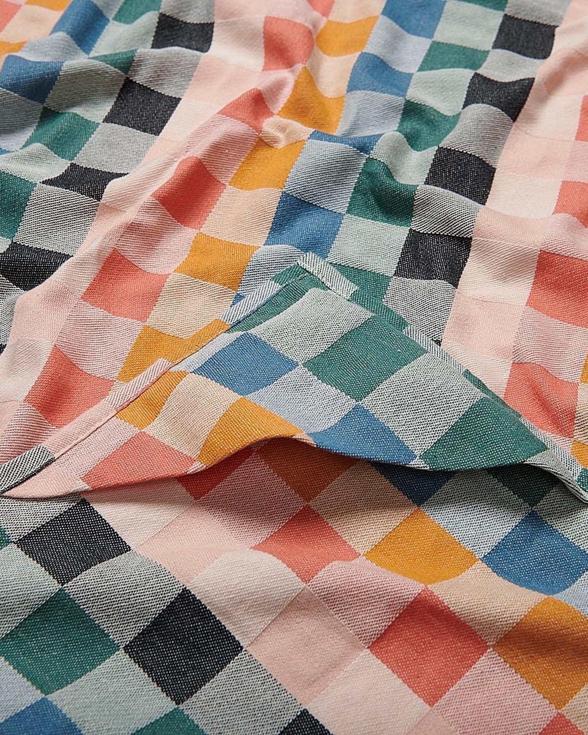 Colorful checkered fabric with a mix of pink, blue, green, and orange patterns