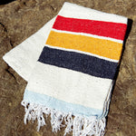 Striped towel with red, yellow, blue, and white on a stone surface