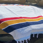 Striped towel with red, yellow, and blue stripes on a rocky surface