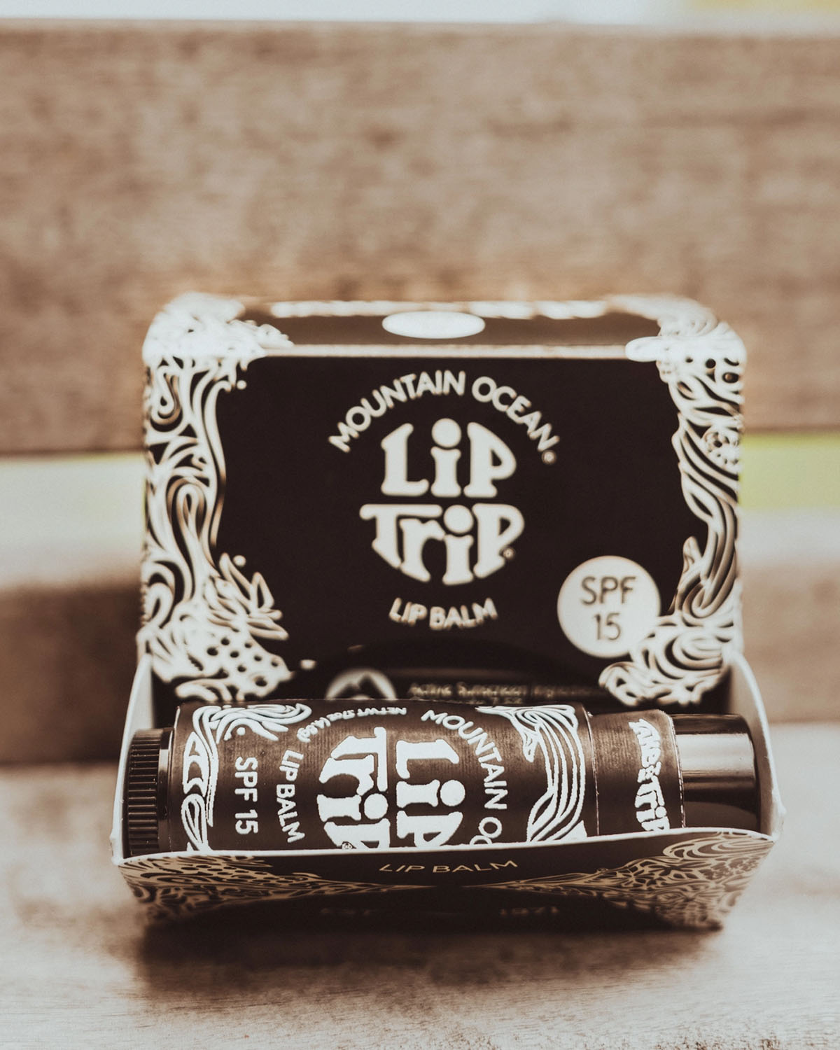 Mountain Ocean Lip Trip lip balm packaging on a wooden surface