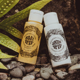 Two bottles of Mountain Ocean body and skin care products on pebbles with a leaf in the background