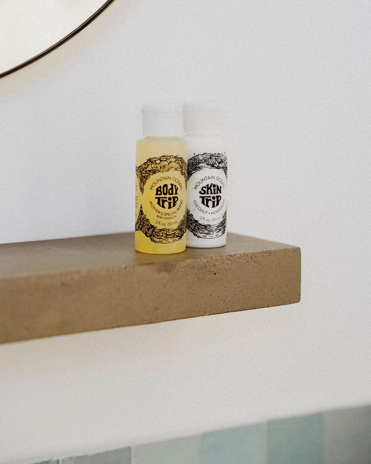 Two bottles of 'Skin Deep' on a wooden shelf with a white background