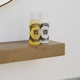 Two bottles of 'Skin Deep' on a wooden shelf with a white background