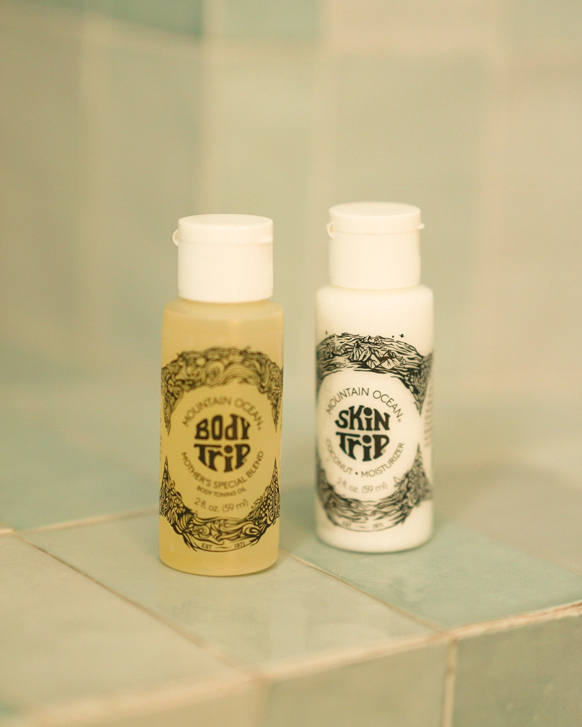 Two bottles of Mountain Ocean skincare products on a tiled surface