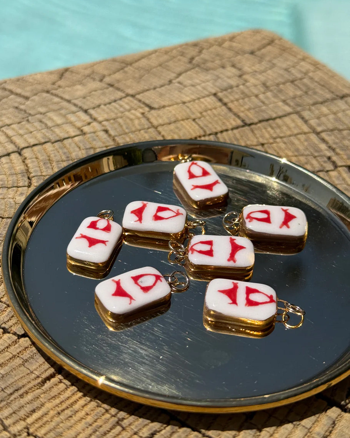 Small rectangular charms with red bikini on them on a reflective surface