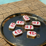 Small rectangular charms with red bikini on them on a reflective surface