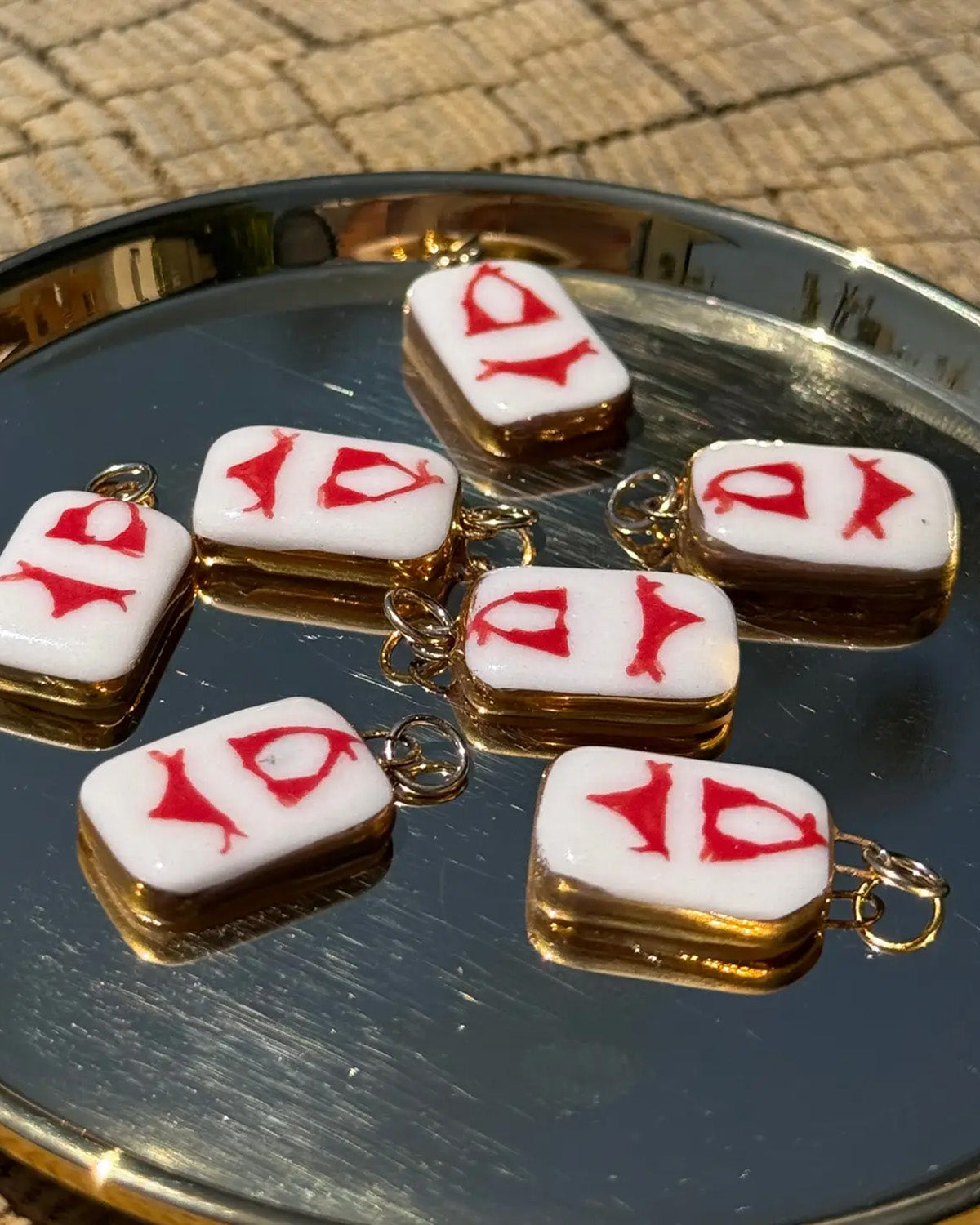 Small square charms with red bikini on a reflective surface