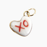 Heart-shaped charm with 'xo' on a white background