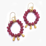 Pair of hoop earrings with pink beads and gold accents on a white background