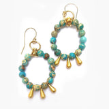 Turquoise and gold beaded hoop earrings on a white background