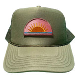 Green trucker cap with a pink and orange sunset patch on a white background