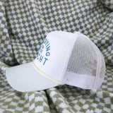 White cap with blue text on a green and white checkered blanket