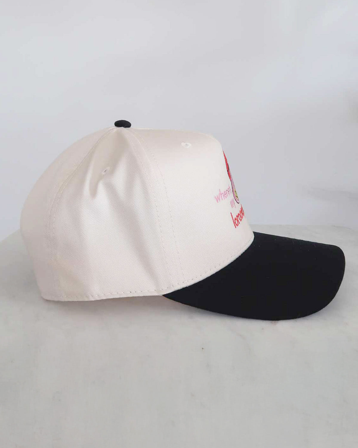 Two-tone cap with white front and black back on a light gray background