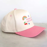 Beige and pink cap with embroidered design on a light gray background