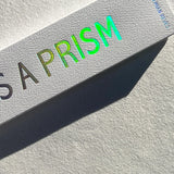 Product packaging with 'PRISM' text in green on a textured surface