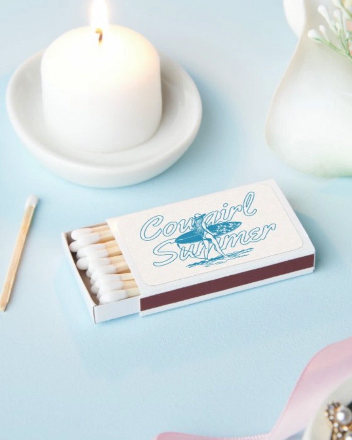Matchbox with 'Cowgirl Summer' design on a light blue background