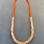 Necklace with orange and peach beads on a gray background