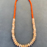Necklace with orange and peach beads on a gray background