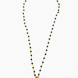 Necklace with black beads and a gold clasp on a white background