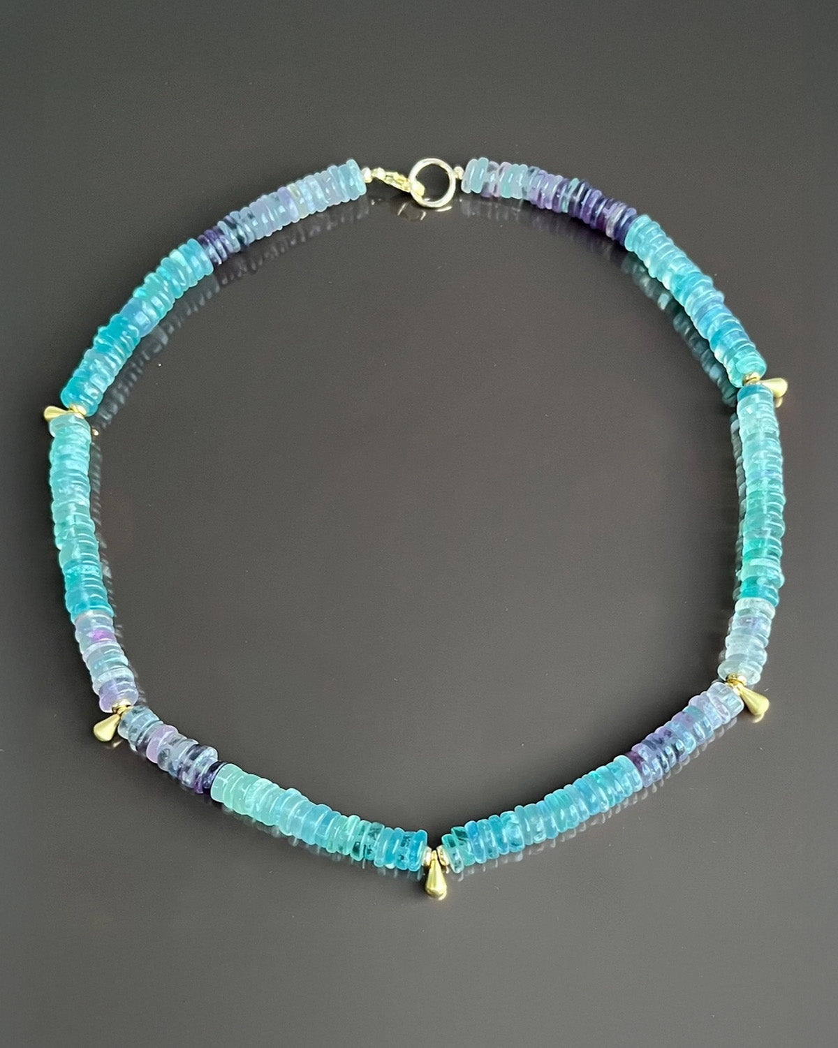 Necklace with blue beads on a dark gray background