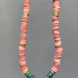 Necklace with pink and green beads on a gray background