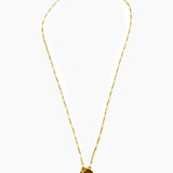 Gold necklace with a small circular pendant on a white background