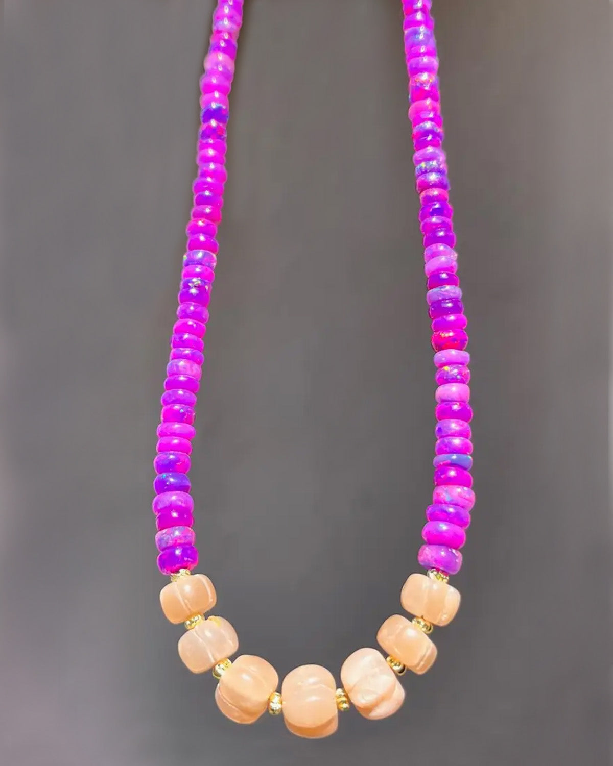 Necklace with pink and purple beads on a gray background