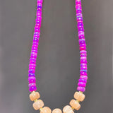Necklace with pink and purple beads on a gray background
