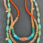 Colorful beaded necklaces on a dark textured surface