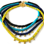 Stack of colorful beaded necklaces on a white background