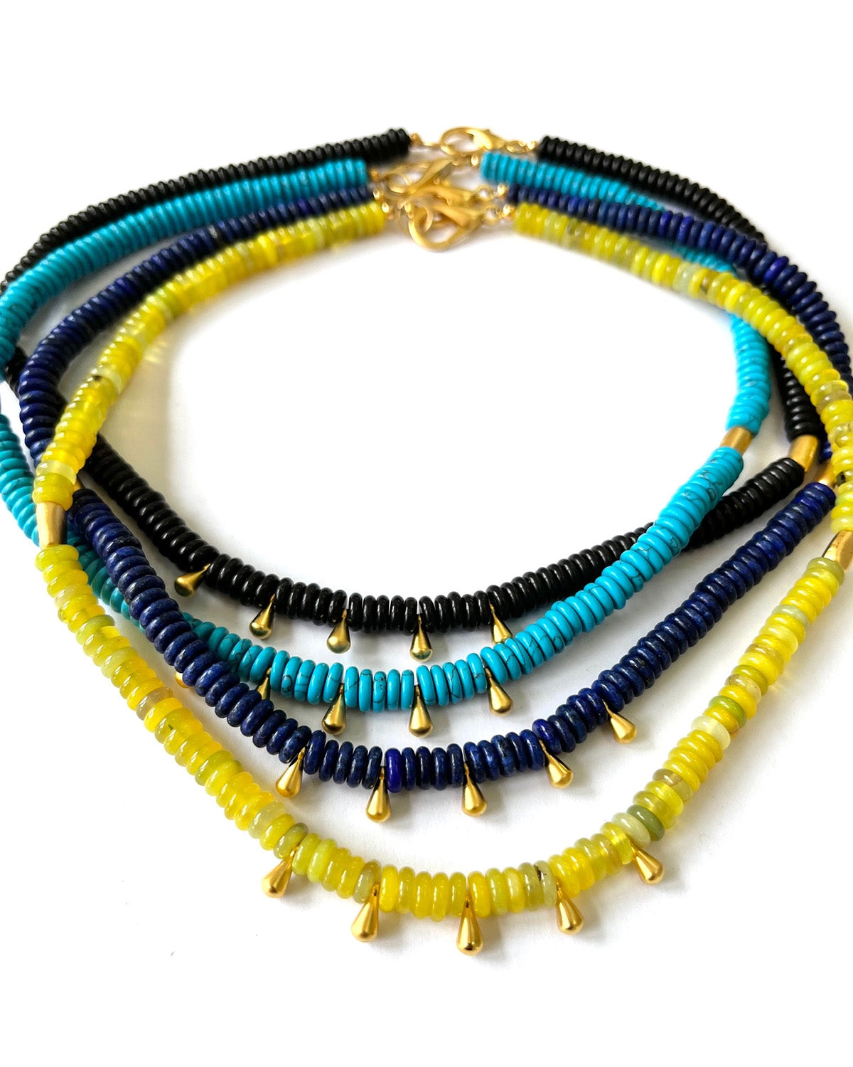 Stack of colorful beaded necklaces on a white background