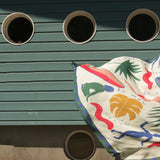 Colorful abstract design on a white surface against a green metal background with circular holes